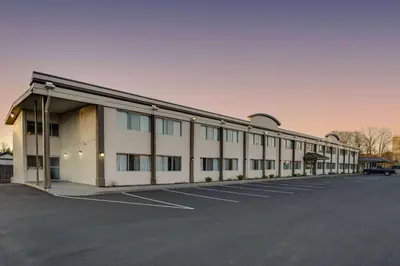 a large white building with a parking lot at Days Inn by Wyndham Albany SUNY in Albany