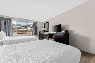 a hotel room with two beds and a flat screen tv at Days Inn by Wyndham Albany SUNY in Albany