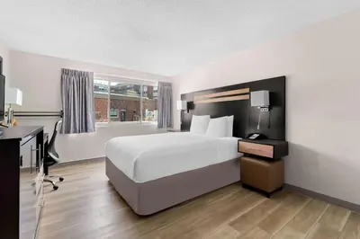 a bedroom with a bed and a desk and a window at Days Inn by Wyndham Albany SUNY in Albany