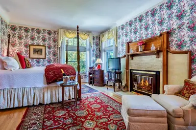 a bedroom with a bed and a fireplace at Wilburton Inn in Manchester