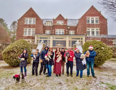a group of people posing in front of a house at Wilburton Inn in Manchester