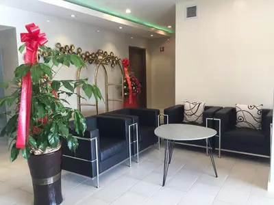 a waiting room with couches and a table and a plant at The Queens Hotel in Queens