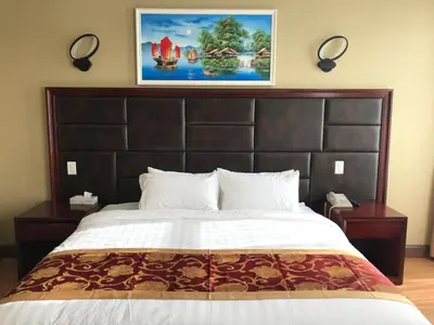 a bedroom with a large bed with a large headboard at The Queens Hotel in Queens