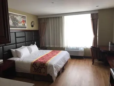 a hotel room with a bed and a window at The Queens Hotel in Queens