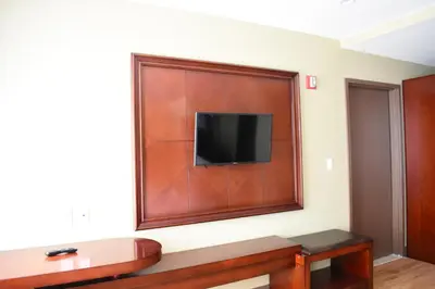 a room with a flat screen tv on a wall at The Queens Hotel in Queens