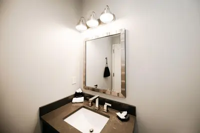 a bathroom with a sink and a mirror at The Railroad Inn in Cooperstown