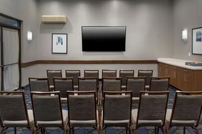 a group of chairs in a room with a flat screen tv at Courtyard by Marriott New Haven Orange in Orange