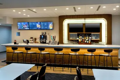 a bar in a hotel room with stools at Courtyard by Marriott New Haven Orange in Orange
