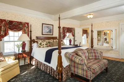 a bedroom with a bed and a couch and a chair at The INN at Ormsby Hill in Manchester