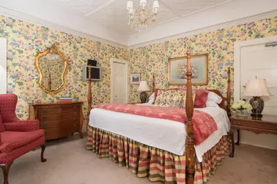 a bedroom with a bed with floral wallpaper at The INN at Ormsby Hill in Manchester