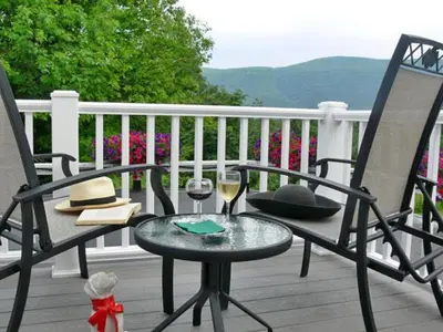 a table and two chairs on a porch with wine glasses at The INN at Ormsby Hill in Manchester