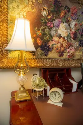 a lamp on a table with a painting and a clock at Daniel Stebbins B and B in South Hadley
