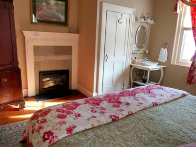 a bedroom with a bed with pink flowers on it at Daniel Stebbins B and B in South Hadley