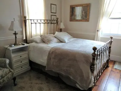 a bedroom with a large bed and a chair at Daniel Stebbins B and B in South Hadley