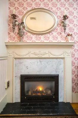 a fireplace with a mirror on top of it at Daniel Stebbins B and B in South Hadley
