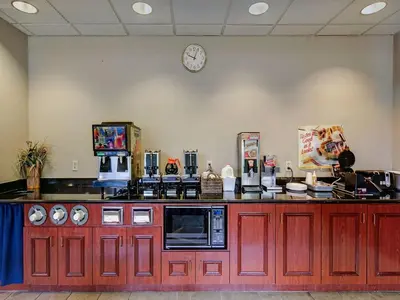 a kitchen with red cabinets and a clock on the wall at Red Carpet INN Whippany in Whippany