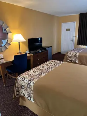 a hotel room with two beds and a desk with a computer at Executive Inn Schenectady Downtown in Schenectady