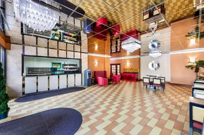 a lobby with a table and chairs in a room at Rodeway Inn Capri in Little Ferry