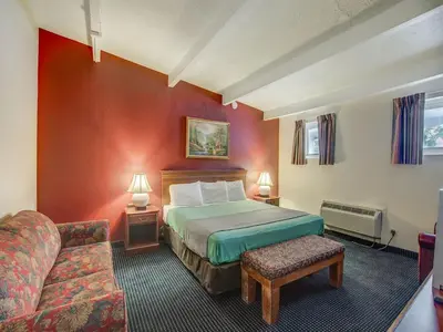 a hotel room with a bed and a couch at Scottish Inn Whippany in Whippany