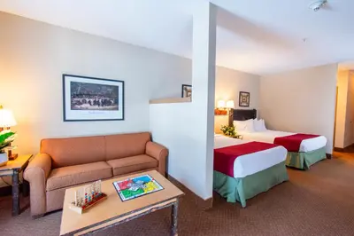 a hotel room with a couch and two beds at Six Flags Great Escape Lodge & Indoor Waterpark in Queensbury