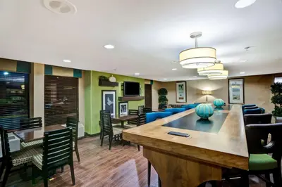 a lobby with a bar and chairs and a dining room at Hampton Inn by Hilton Milford in Milford