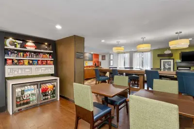 a restaurant with a table and chairs and a refrigerator at Hampton Inn by Hilton Milford in Milford