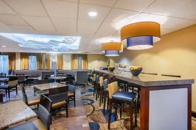a restaurant with a bar and tables and chairs at Hampton Inn Fishkill in Fishkill