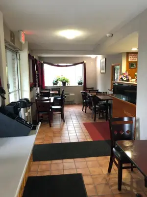 a restaurant with tables and chairs and a bar at Latham Inn in Latham