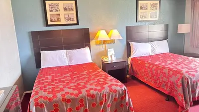 a hotel room with two beds next to each other at Latham Inn in Latham