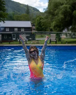 a woman in a bikini in a swimming pool at Catskill Seasons Inn in Shandaken