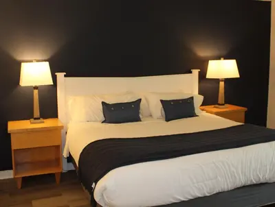 a bedroom with a large white bed with two lamps at Catskill Seasons Inn in Shandaken