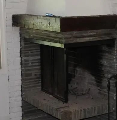 a brick fireplace with a wooden mantel at Catskill Seasons Inn in Shandaken