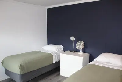 a bedroom with two beds and a night stand with a fan at Catskill Seasons Inn in Shandaken
