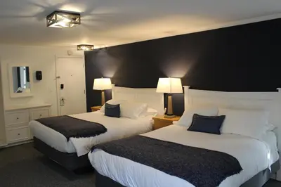 two beds in a hotel room with a black wall at Catskill Seasons Inn in Shandaken
