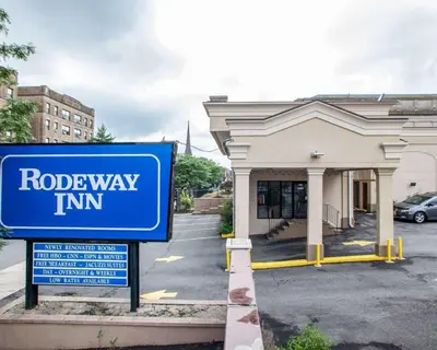 a blue road way inn sign in front of a building at Rodeway Inn Paterson Great Falls Park Area in Paterson