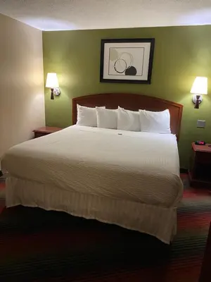 a hotel room with a large bed with white pillows at Ramada by Wyndham Rochelle Park Near Paramus in Rochelle Park