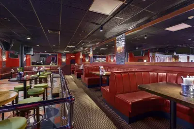 a restaurant with red leather seats and tables at Ramada by Wyndham Rochelle Park Near Paramus in Rochelle Park