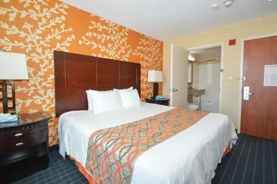 a hotel room with a large bed and a bathroom at Corona Hotel New York - LaGuardia Airport in Queens