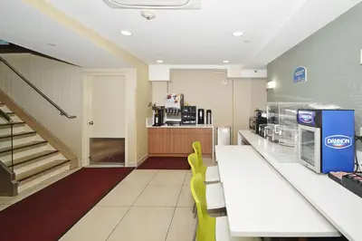 a fast food restaurant with a counter and yellow chairs at Corona Hotel New York - LaGuardia Airport in Queens