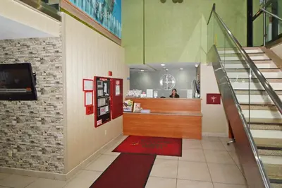 a lobby with a red phone booth and stairs at Corona Hotel New York - LaGuardia Airport in Queens