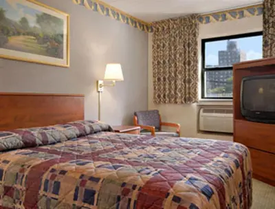 a hotel room with a bed and a television at Super 8 by Wyndham Long Island City LGA Hotel in Queens