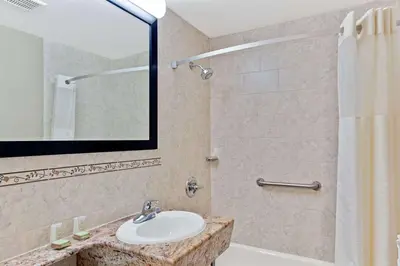 a bathroom with a sink and a shower with a mirror at Super 8 by Wyndham Long Island City LGA Hotel in Queens