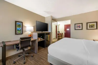 a hotel room with a bed and a desk with a computer at Comfort Inn & Suites East Hartford - Hartford in East Hartford