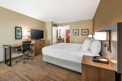 a hotel room with a bed and a desk with a computer at Comfort Inn & Suites East Hartford - Hartford in East Hartford