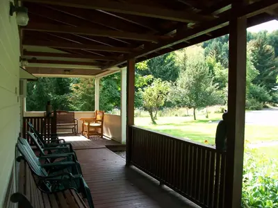 a porch with chairs and a view of a park at Mohican Motel in Cooperstown