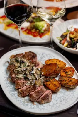 a table with plates of food and glasses of wine at Four Points by Sheraton Manhattan SoHo Village in New York