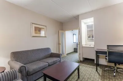 a living room with a couch and a flat screen tv at Ramada by Wyndham Newburgh/West Point in Newburgh