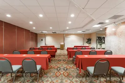 a conference room with red tables and chairs at Ramada by Wyndham Newburgh/West Point in Newburgh