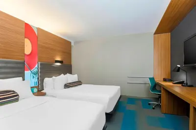a hotel room with two beds and a television at Aloft Harlem in New York
