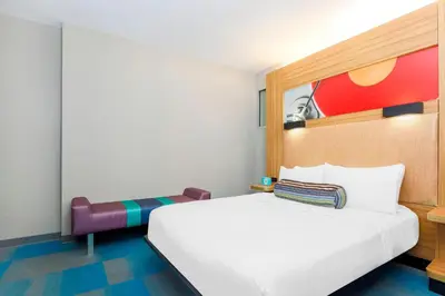 a bedroom with a large white bed and a chair at Aloft Harlem in New York